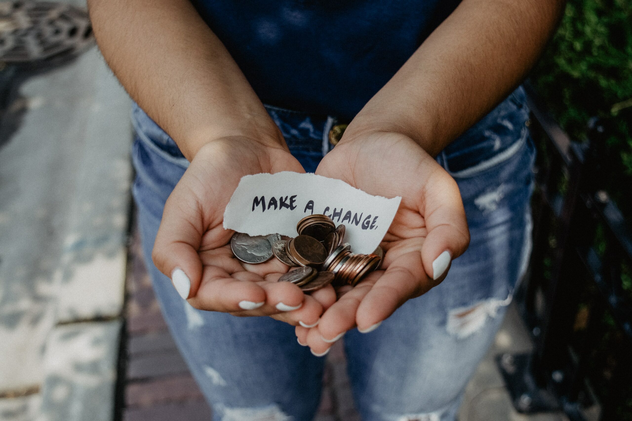 person's open palms with coins and make a change note