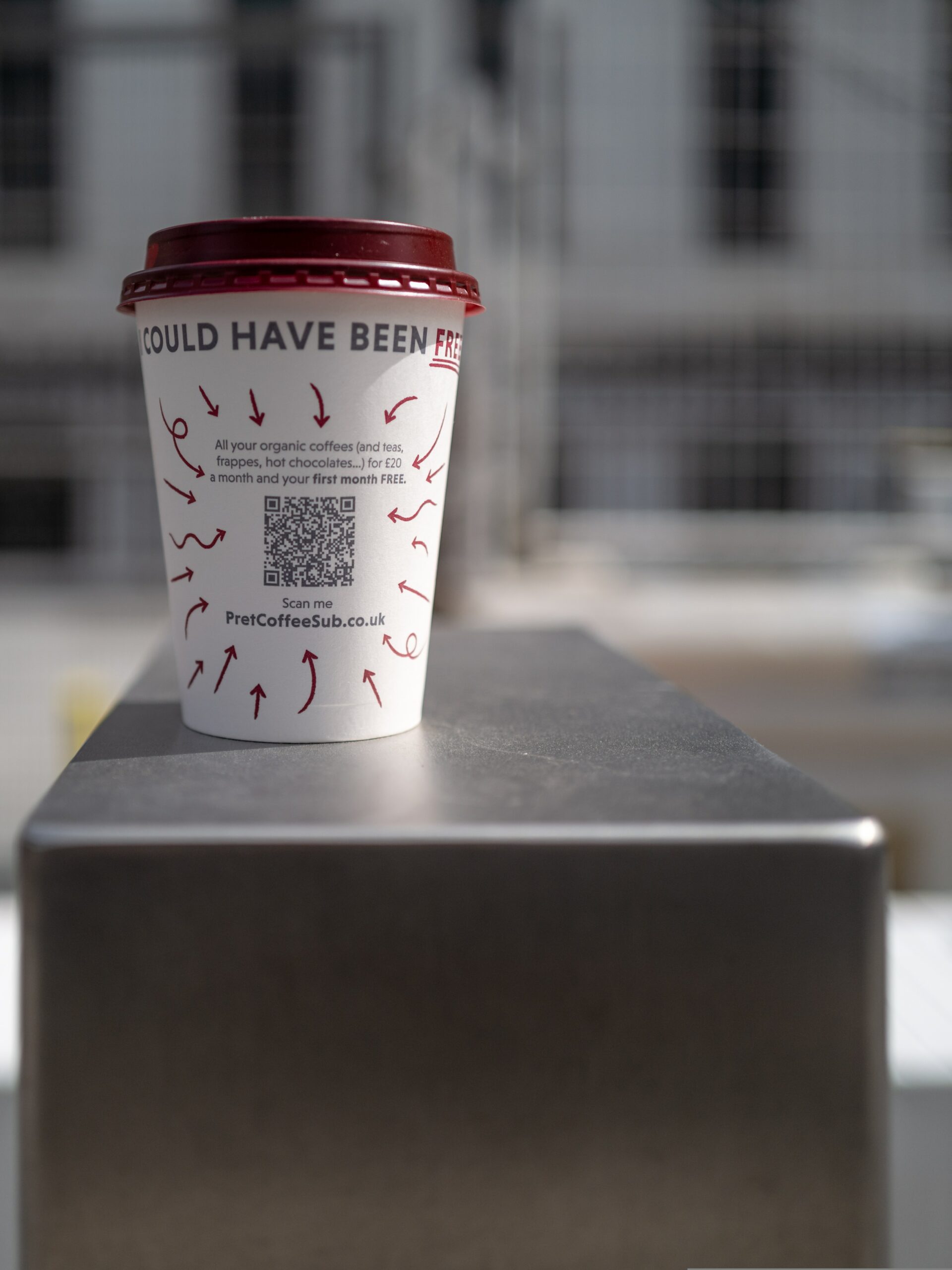 qr codes on coffee cups, white coffee cup with red lid on metallic surface