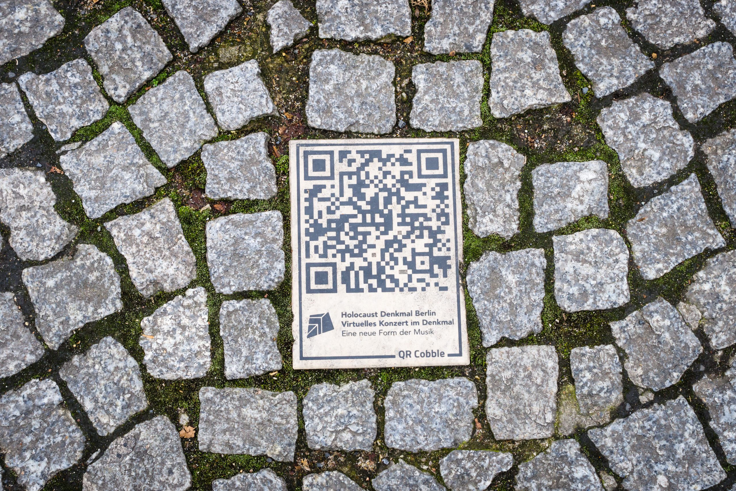 QR Codes for Funerals BERLIN - NOVEMBER 12, 2017: QR-code on the pavement. A modern way of submitting information about attractions.